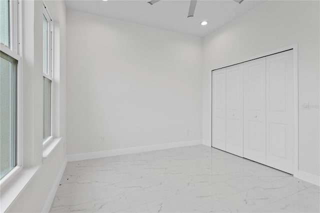 unfurnished bedroom featuring recessed lighting, multiple windows, baseboards, and marble finish floor