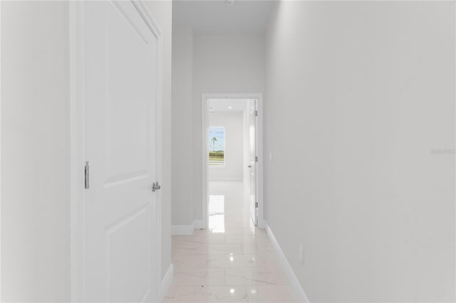 hallway with baseboards and marble finish floor