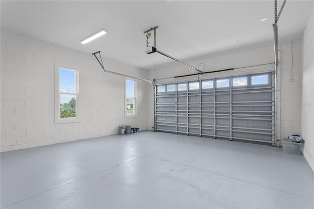 garage with concrete block wall and a garage door opener