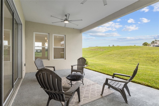 view of patio featuring ceiling fan and an outdoor fire pit