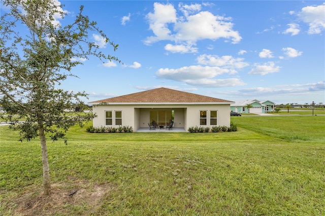 rear view of property with a yard and a patio area