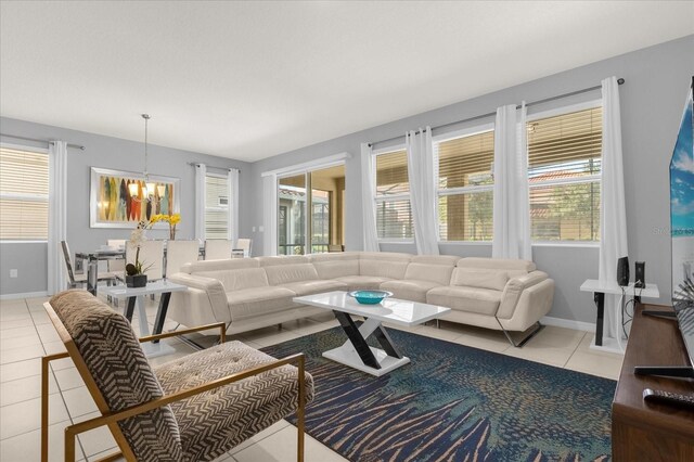 living room featuring an inviting chandelier, light tile patterned flooring, and a healthy amount of sunlight