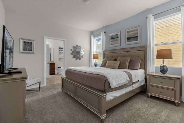 carpeted bedroom featuring ensuite bath