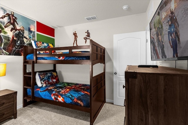 bedroom featuring light colored carpet and a textured ceiling