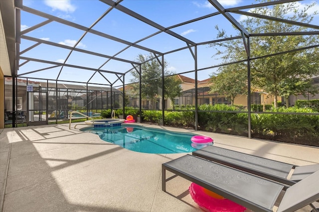 view of pool with a patio area, glass enclosure, and an in ground hot tub