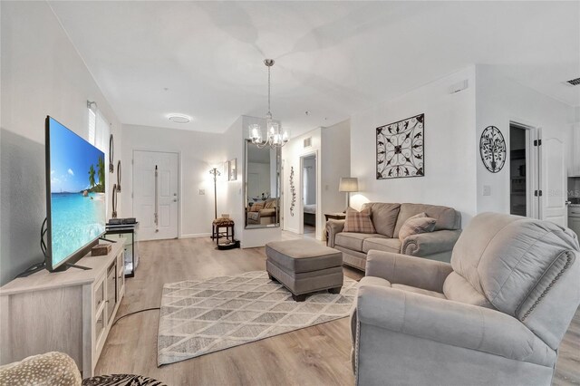 living room with an inviting chandelier and light wood-type flooring