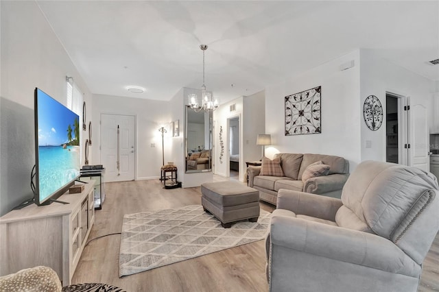 living room with a notable chandelier and light hardwood / wood-style floors