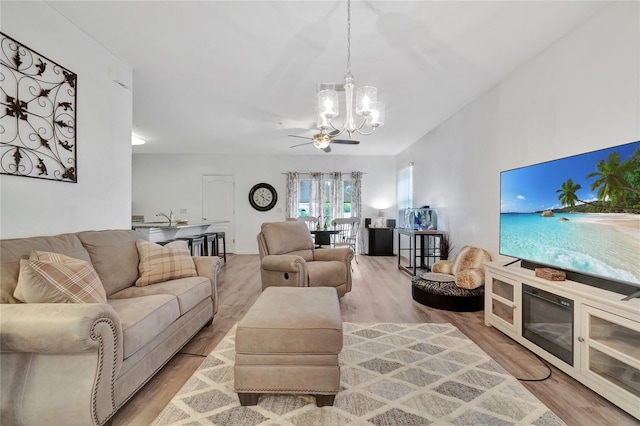 living room featuring sink, ceiling fan with notable chandelier, and light wood-type flooring