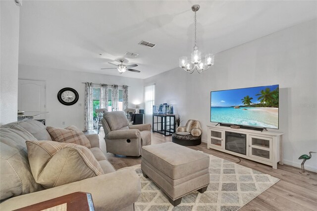 living room featuring ceiling fan with notable chandelier and light wood-type flooring