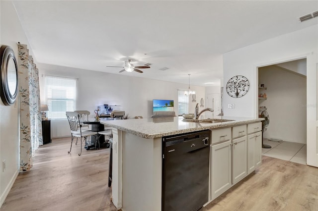 kitchen featuring dishwasher, light hardwood / wood-style flooring, ceiling fan with notable chandelier, and an island with sink