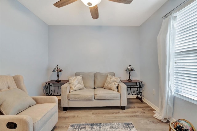 living room with light wood-type flooring, ceiling fan, and a wealth of natural light