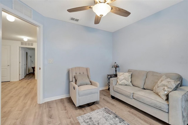 living room with light hardwood / wood-style flooring and ceiling fan