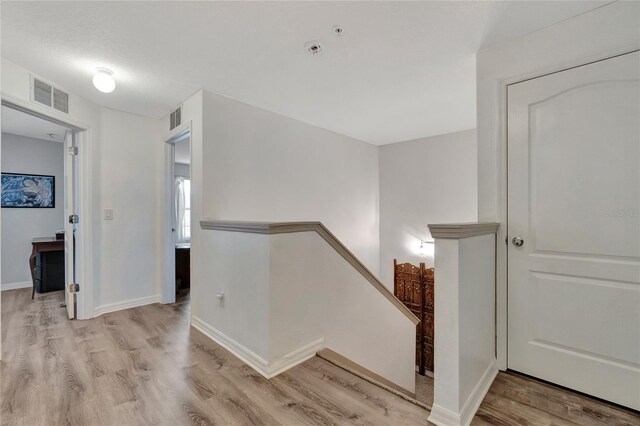 stairway with light hardwood / wood-style floors