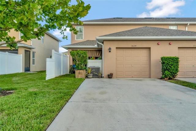 view of front of home featuring a garage, central air condition unit, and a front lawn