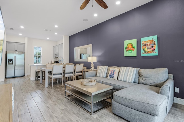 living room with ceiling fan and light hardwood / wood-style floors