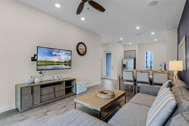 living room featuring light wood-type flooring and ceiling fan