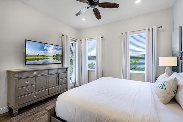 bedroom with multiple windows, dark hardwood / wood-style floors, and ceiling fan