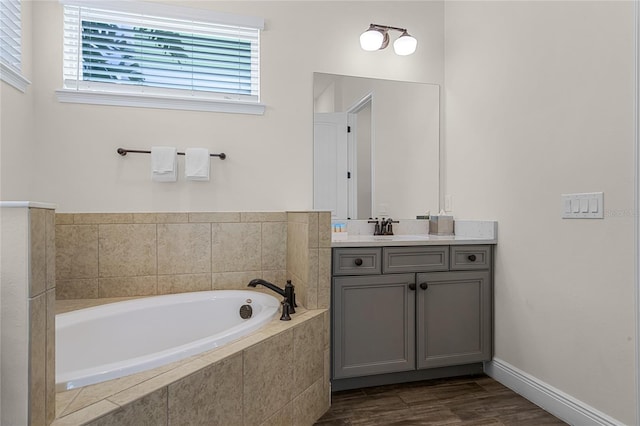 bathroom with a relaxing tiled tub and vanity