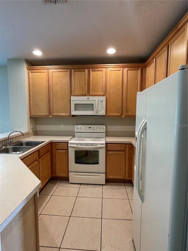 kitchen with white appliances, sink, a textured ceiling, and light tile patterned floors