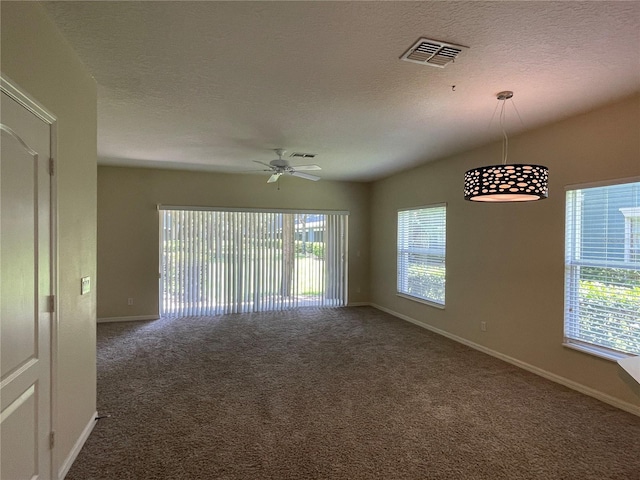 carpeted empty room with ceiling fan and a textured ceiling