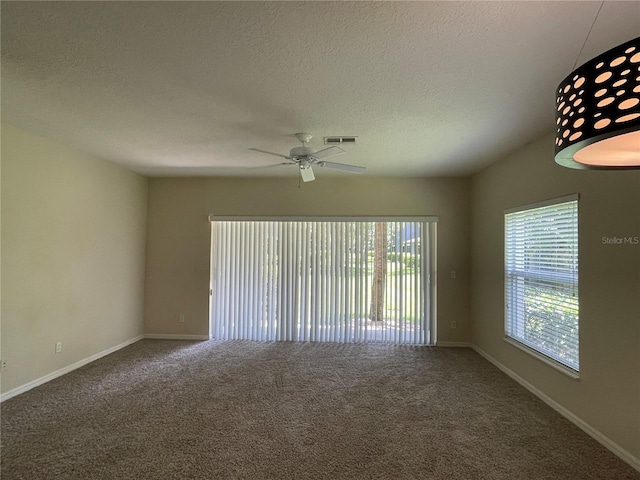 unfurnished room with ceiling fan, a textured ceiling, and carpet