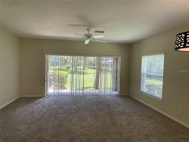 carpeted spare room with ceiling fan and a textured ceiling