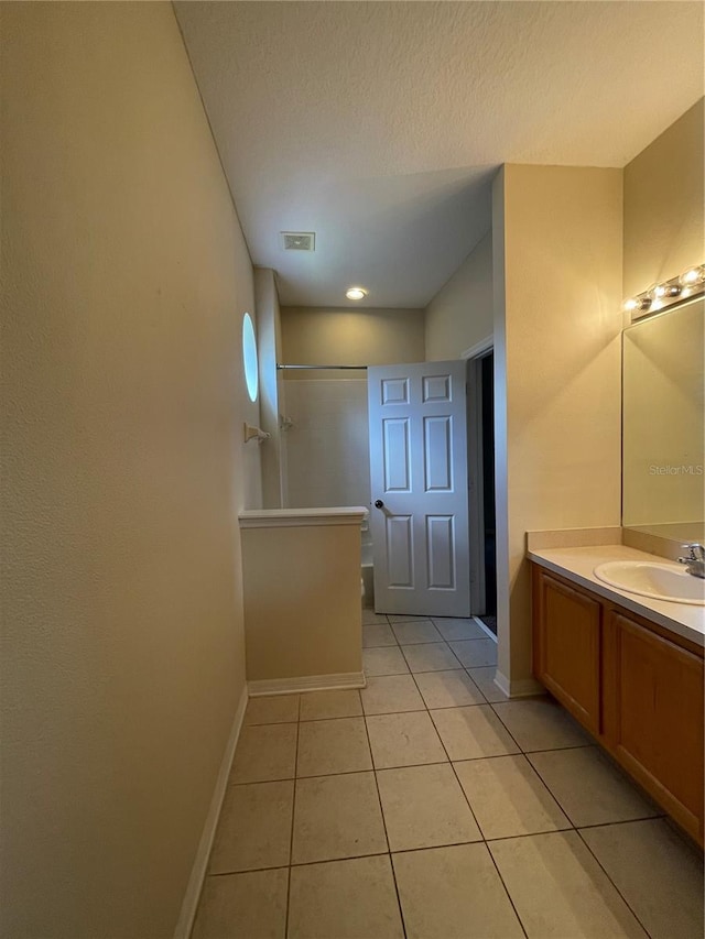 bathroom with vanity, tile patterned floors, and a textured ceiling