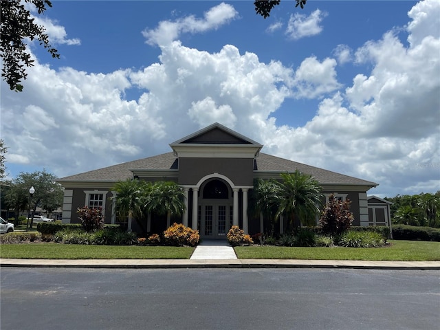 view of front of property with french doors and a front lawn