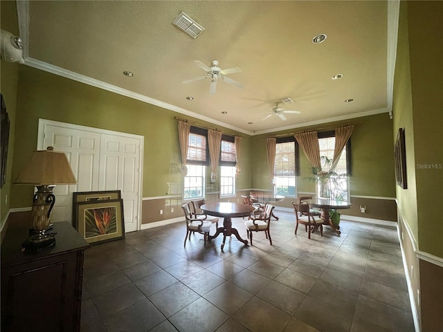 tiled dining space with ceiling fan and ornamental molding