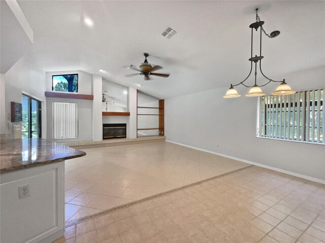 unfurnished living room with lofted ceiling, light tile patterned flooring, and ceiling fan