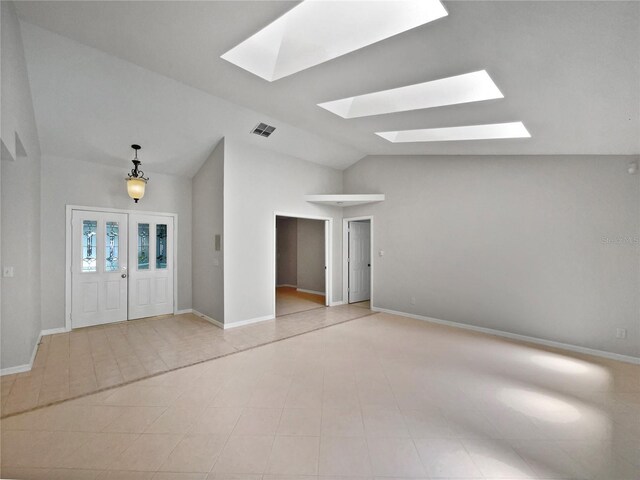 tiled foyer featuring lofted ceiling with skylight