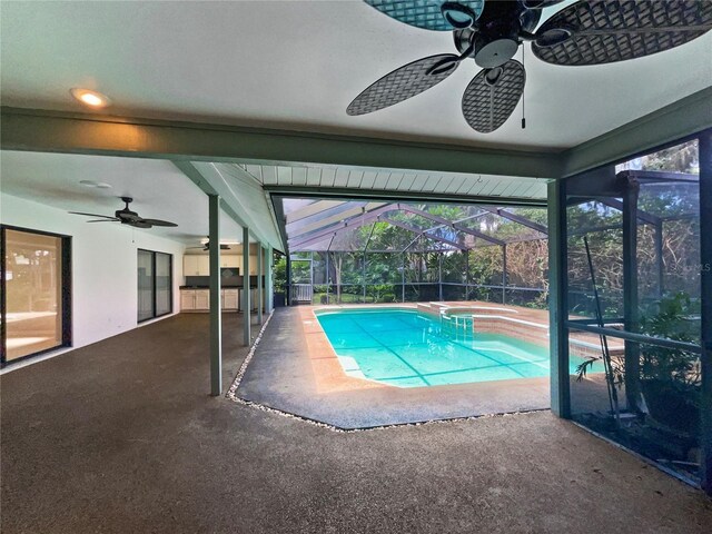 view of pool featuring glass enclosure, a patio, and ceiling fan