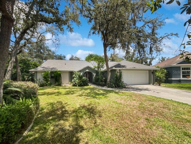 single story home featuring a front lawn and a garage