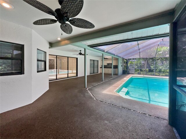 view of pool featuring glass enclosure, a patio area, and ceiling fan