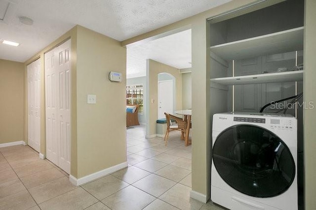 washroom featuring light tile patterned floors, washer / dryer, and a textured ceiling