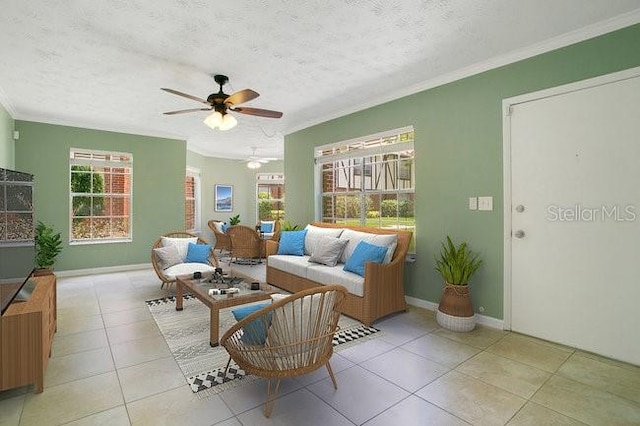 living room featuring a textured ceiling, ornamental molding, ceiling fan, and light tile patterned floors