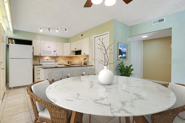 tiled dining space with sink and ceiling fan