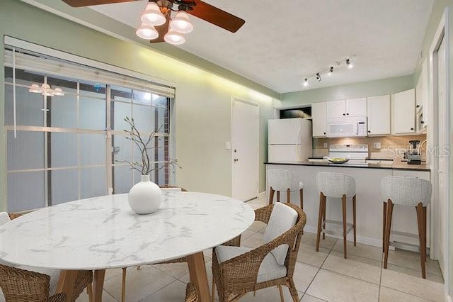 tiled dining space featuring ceiling fan