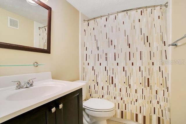 bathroom featuring vanity, a shower with curtain, toilet, and a textured ceiling