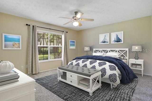 bedroom with ceiling fan, carpet flooring, and a textured ceiling