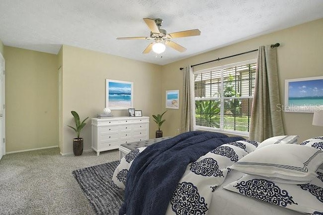 bedroom featuring ceiling fan, light colored carpet, and a textured ceiling