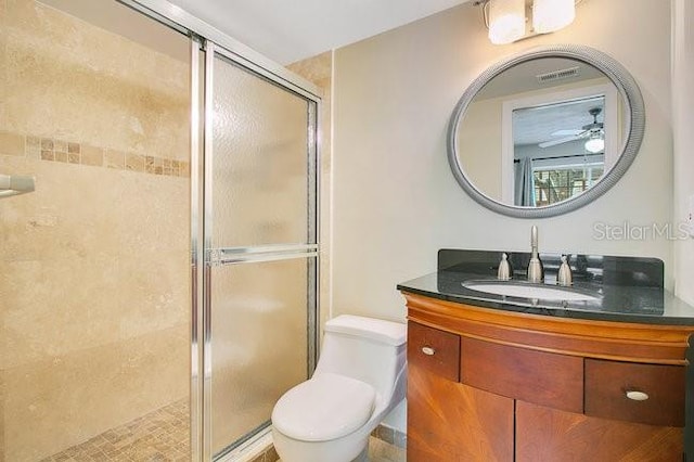 bathroom with vanity, a shower with shower door, and toilet