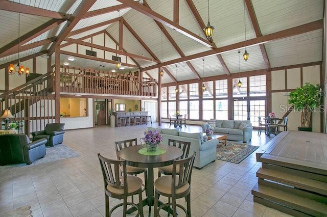 tiled dining area with an inviting chandelier, high vaulted ceiling, and beamed ceiling