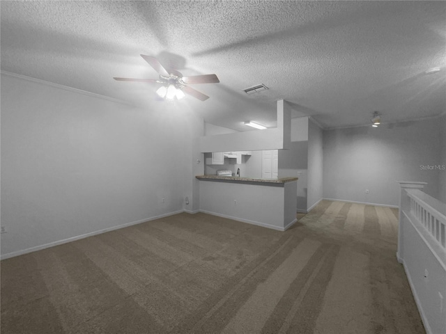 unfurnished living room with ceiling fan, a textured ceiling, and carpet floors