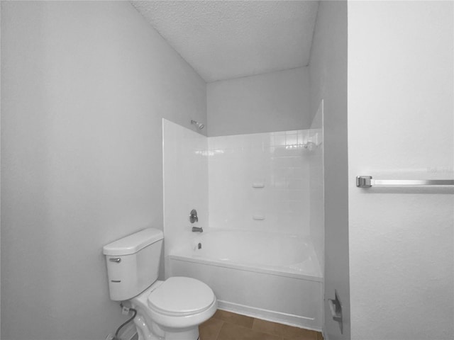 bathroom with shower / bathing tub combination, a textured ceiling, and toilet