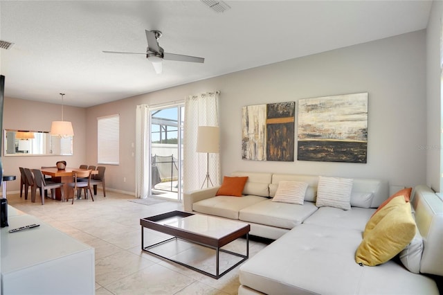 tiled living room featuring ceiling fan