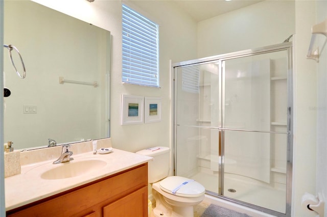 bathroom featuring vanity, walk in shower, and toilet