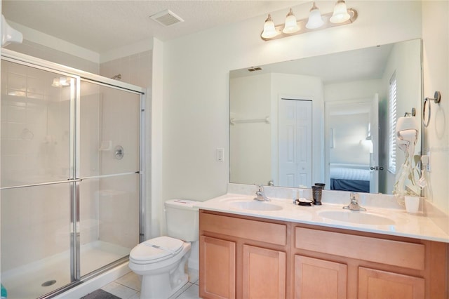 bathroom with tile patterned flooring, walk in shower, a textured ceiling, toilet, and double sink vanity