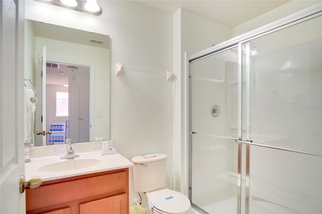 bathroom with vanity, toilet, and an enclosed shower