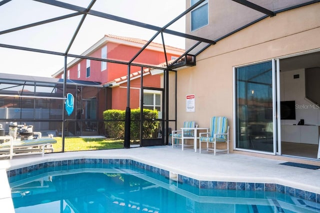 view of swimming pool featuring a patio area and a lanai